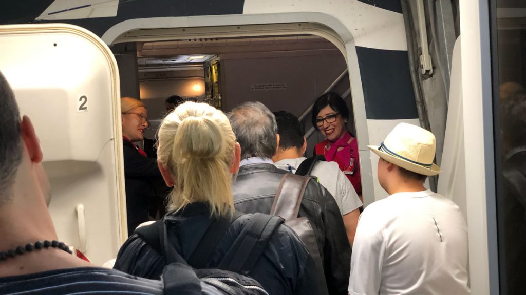 a group of people standing in a doorway of an airplane