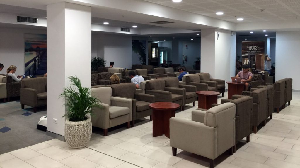 a group of people sitting in a room with chairs and tables