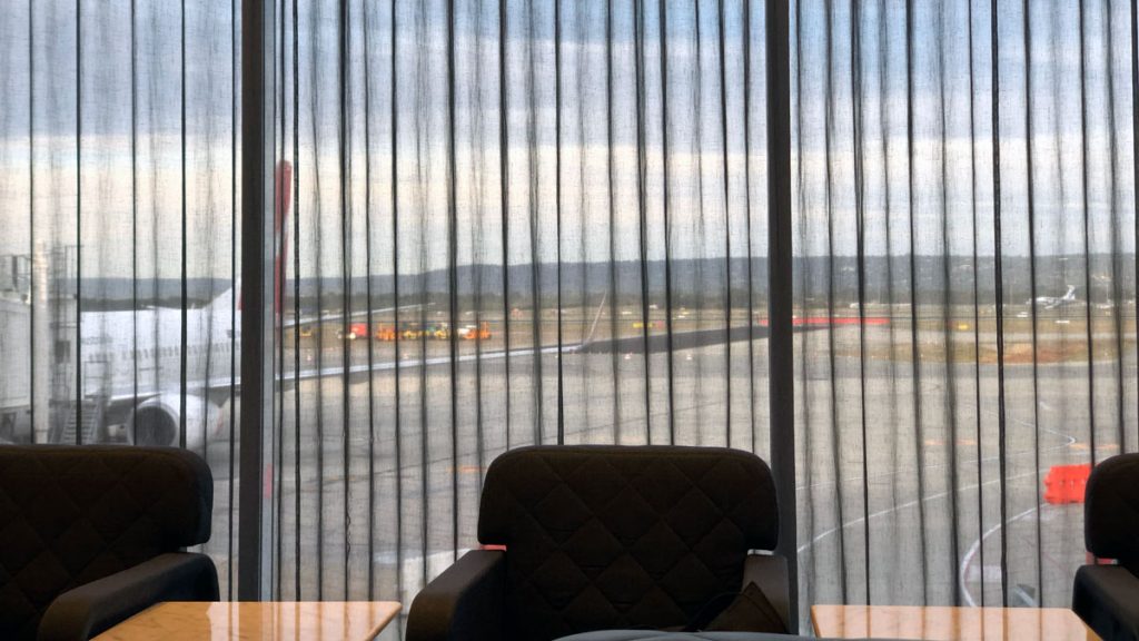 a chair and table with a view of the runway from the window