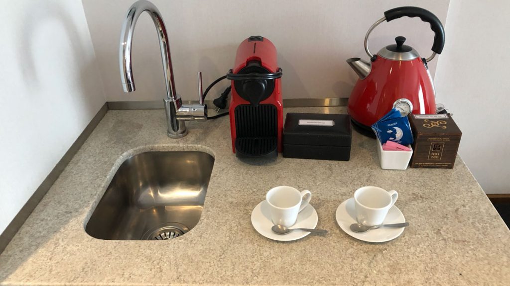 a kitchen counter with a red kettle and tea cups