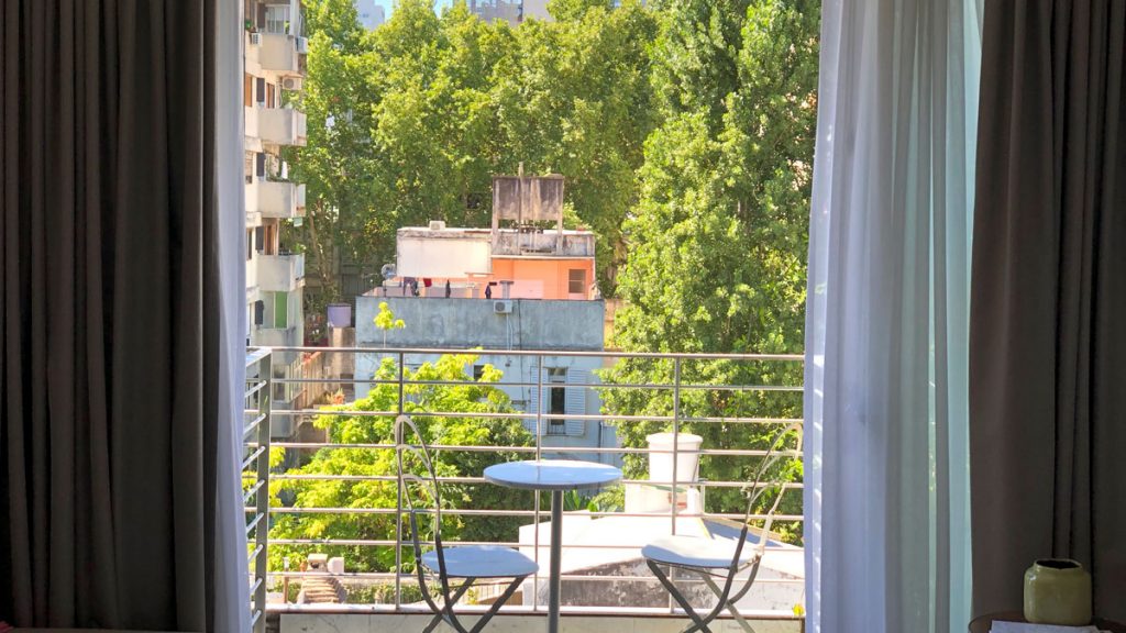 a balcony with a table and chairs and trees