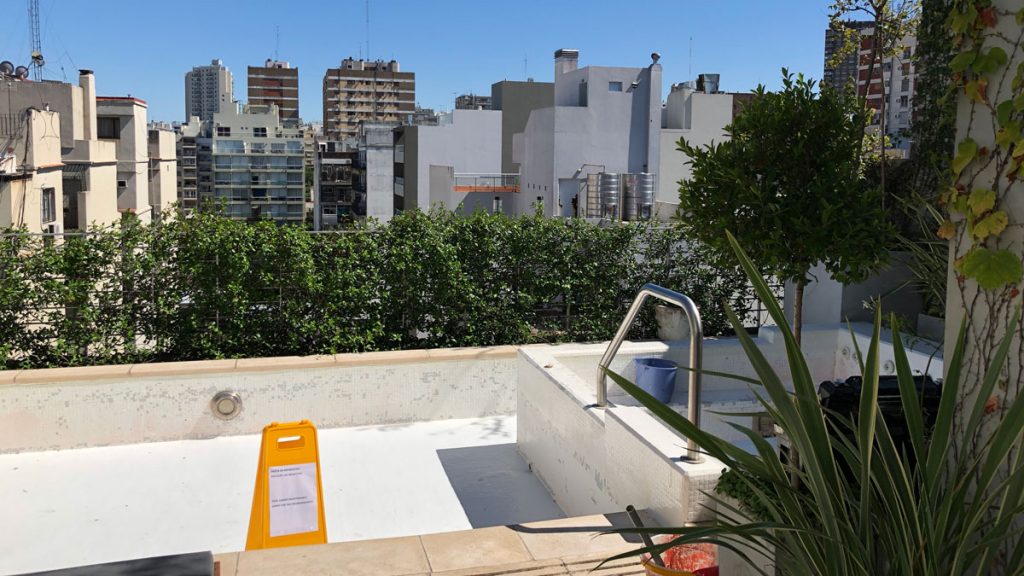 a pool with a metal railing and a green plant