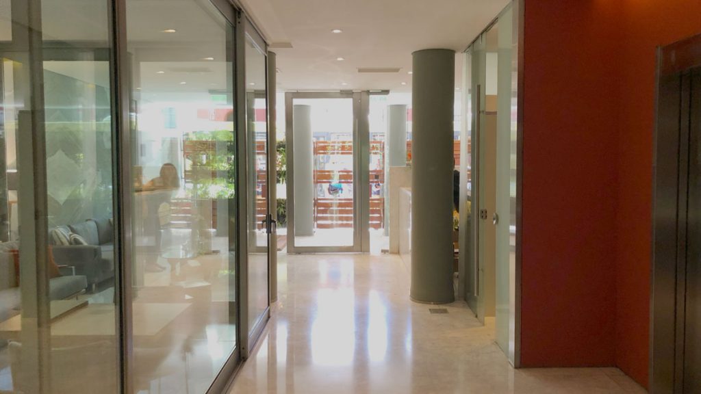 a hallway with glass doors and a person standing in the background