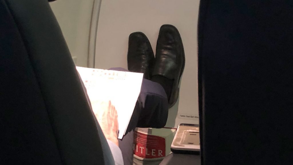 a person's legs and feet on an airplane