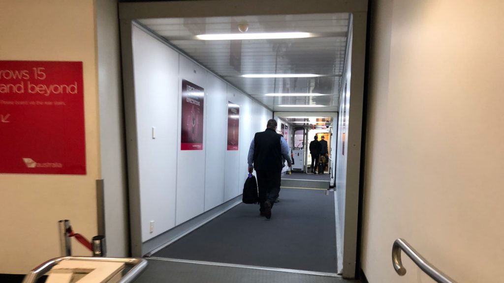 a man walking down a hallway with a luggage bag