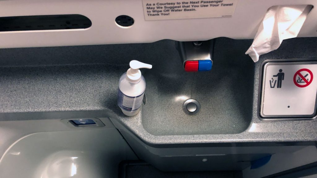 a sink with a bottle of liquid and a button