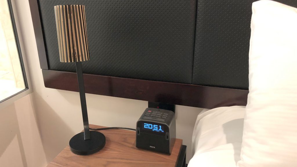 a lamp on a table next to a bed