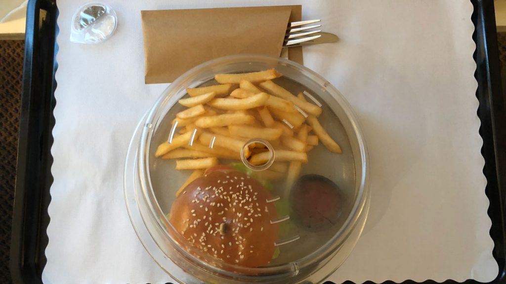 a hamburger and fries in a plastic container
