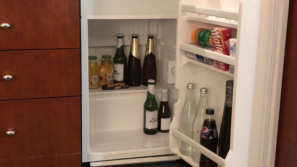 a refrigerator with bottles of beer and snacks
