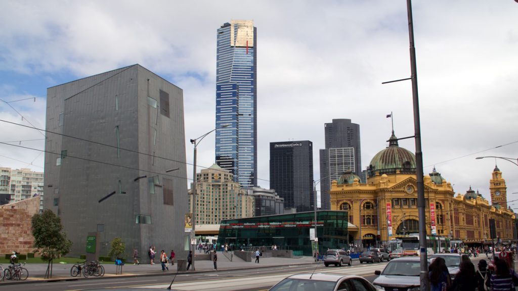 a city street with a tall building and people walking