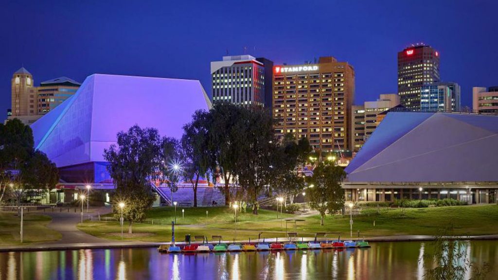 a water body with boats in it and buildings in the background