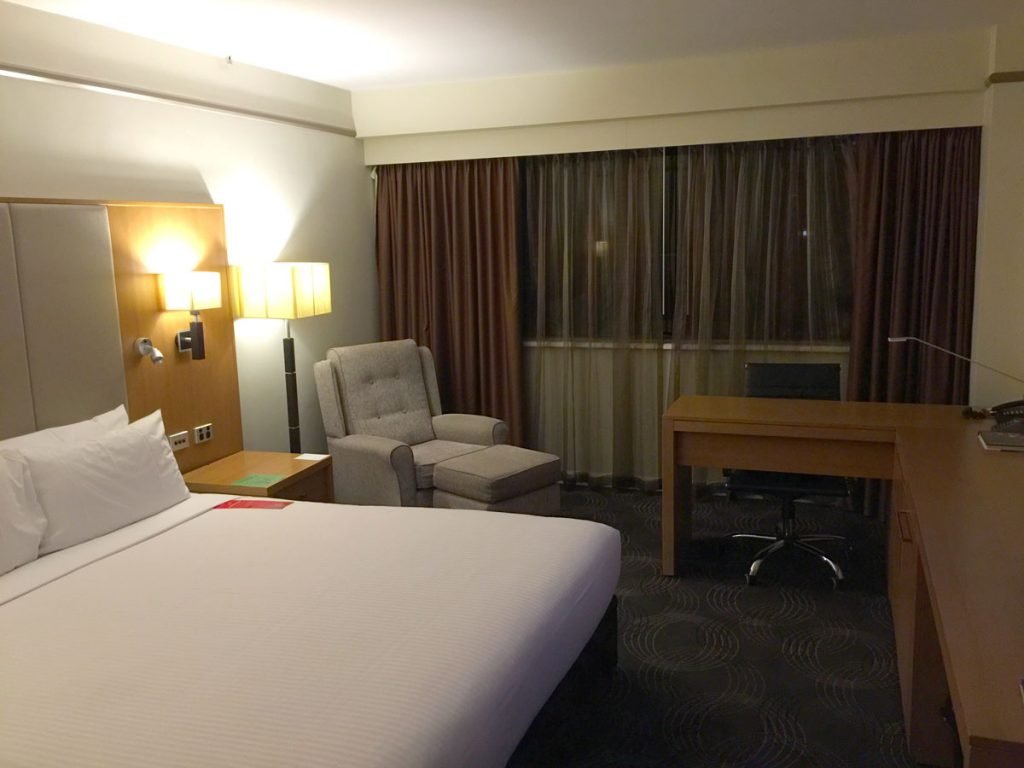 a hotel room with a bed and a desk and chair
