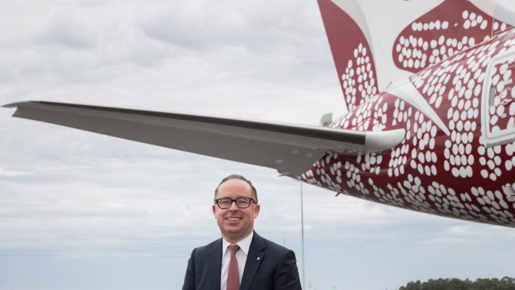 a man in a suit standing in front of a plane