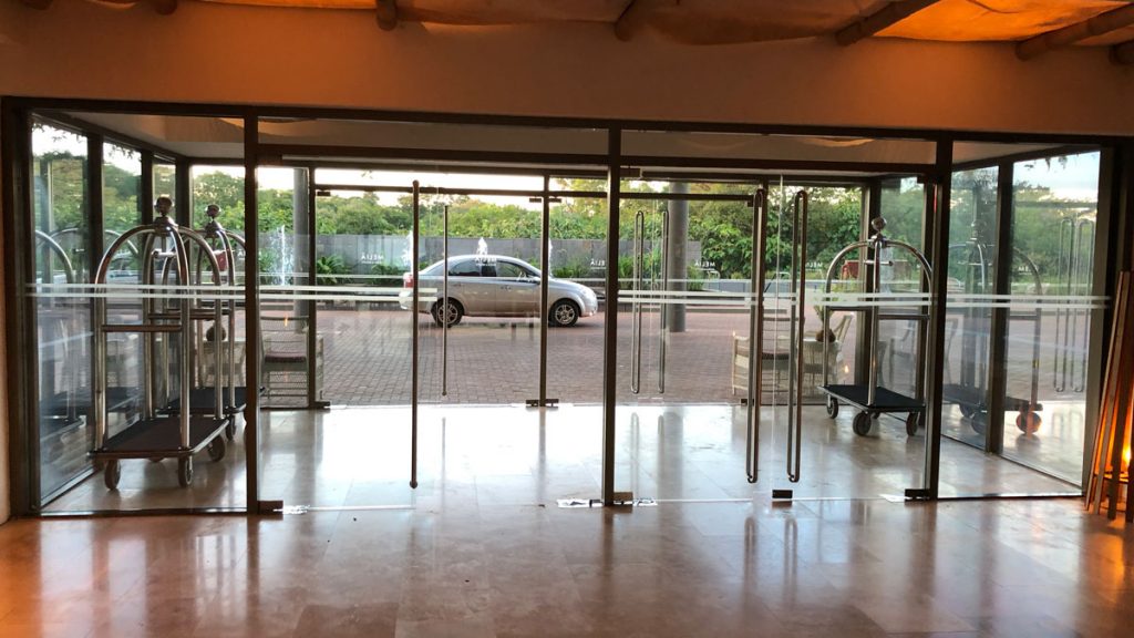 a glass door with a car in the background