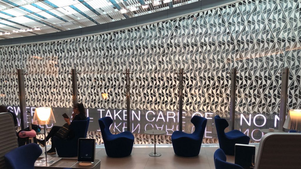 a group of people sitting in chairs in a room with a wall of glass