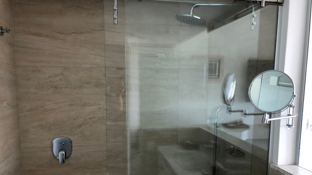 a glass shower door with a bathtub and sink