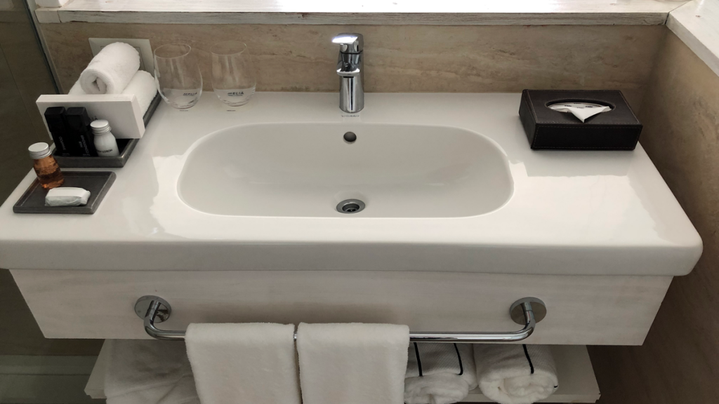 a sink with a towel and glasses on it