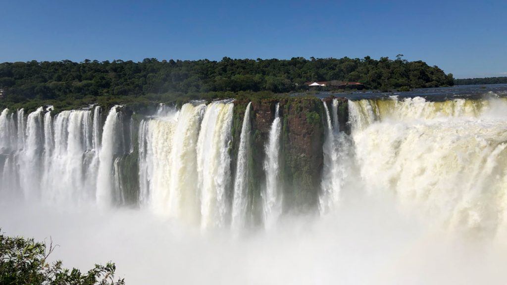 a large waterfall with trees in the background