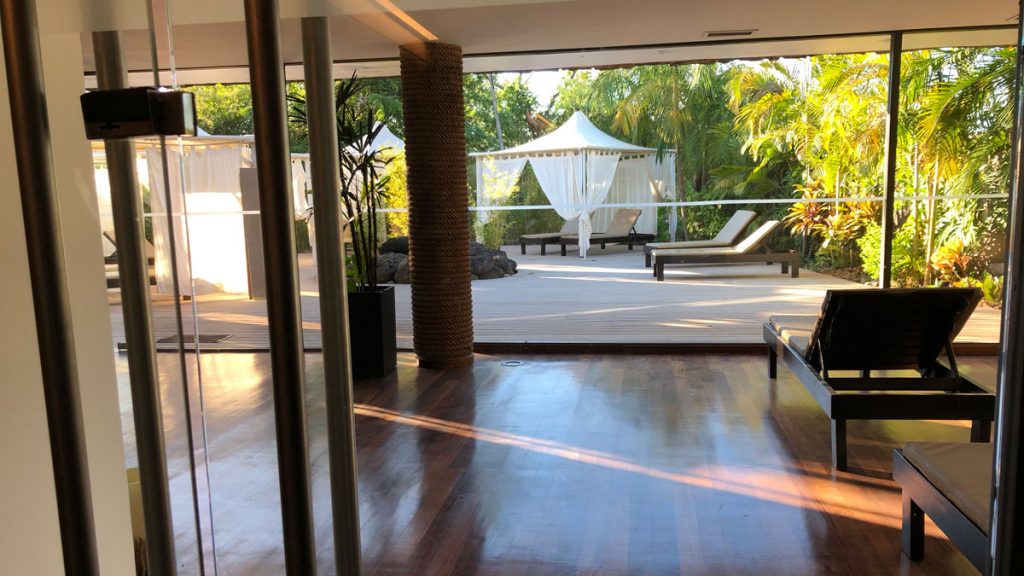 a room with a deck and a patio with a white canopy and trees