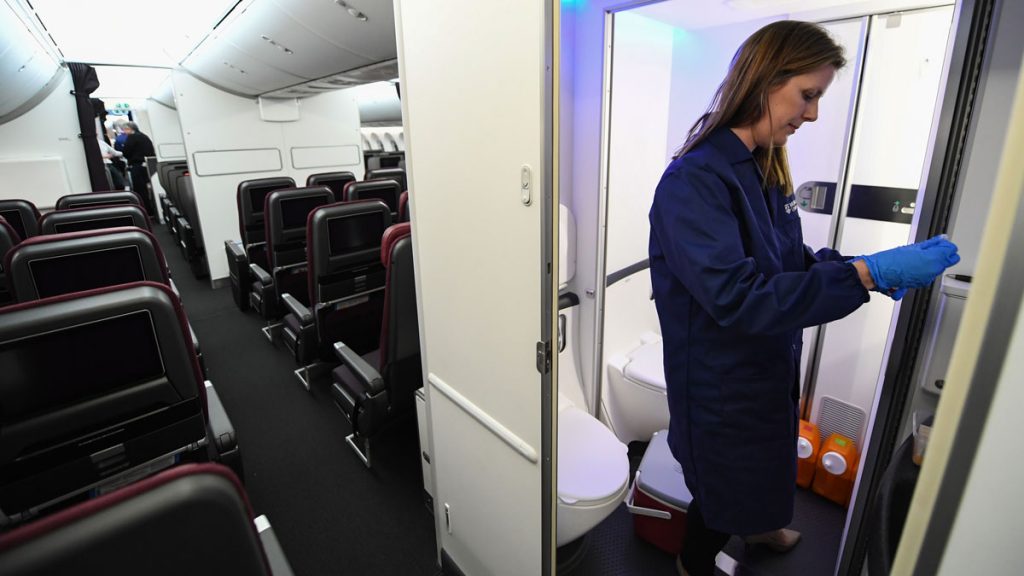 a woman in a blue uniform standing in a plane