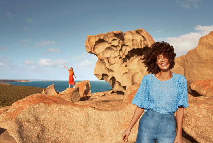 a woman standing in front of a rock formation