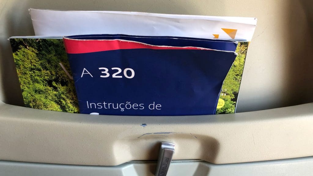 a blue and red booklet in a seat