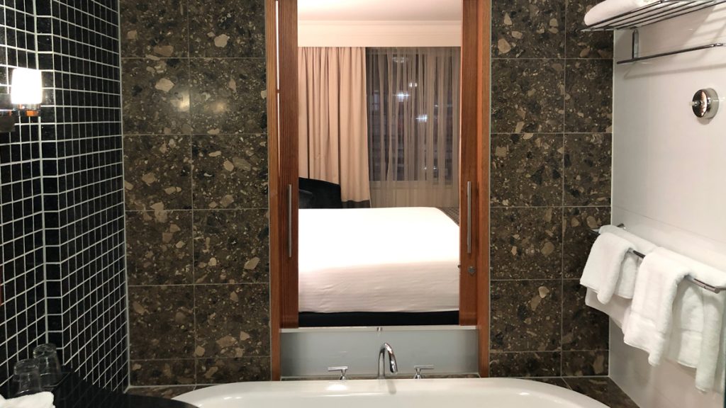 a bathroom with a mirror and a bathtub