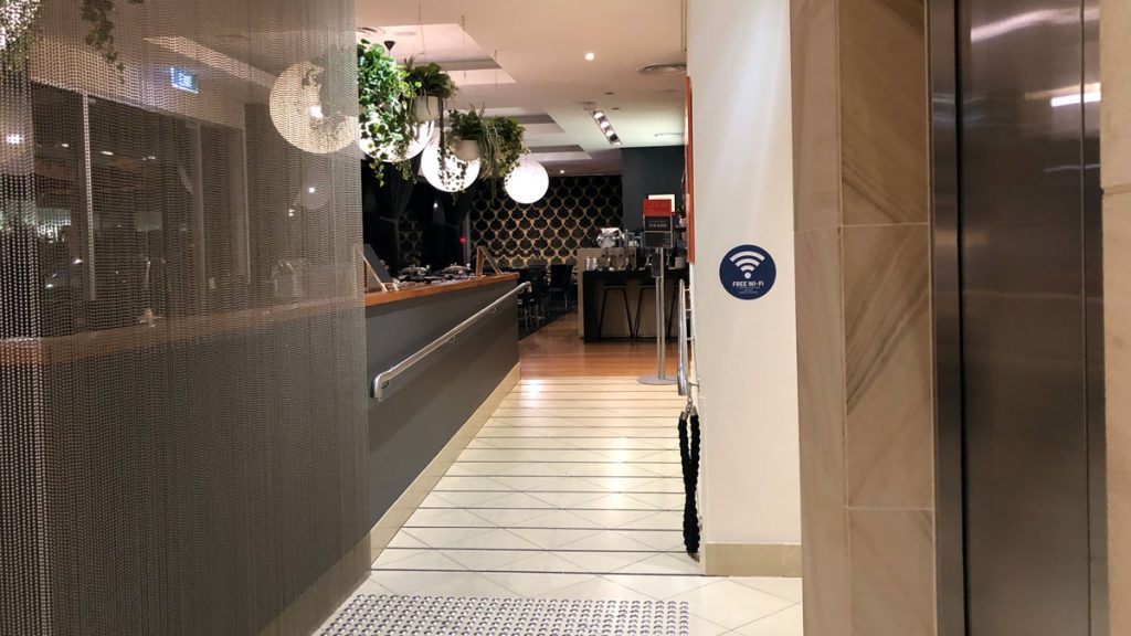 a hallway with a counter and plants from the ceiling