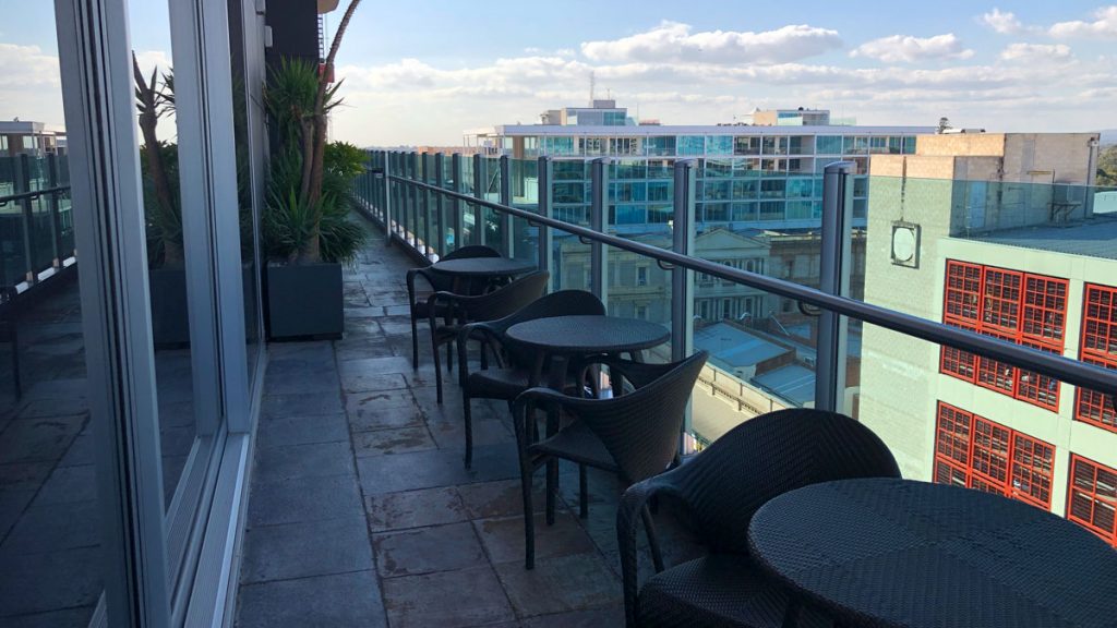 a balcony with chairs and tables