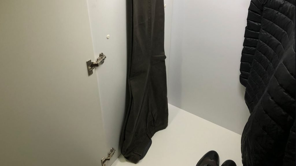 a pair of shoes and a pair of pants on a hook