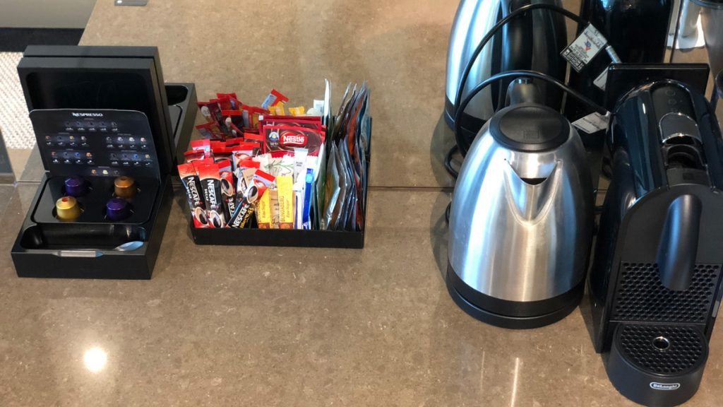 a coffee maker and condiments on a counter