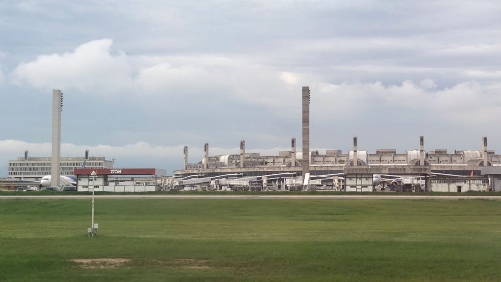 a large building with a large chimney and a green field