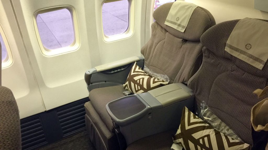a seat with pillows on the side of the plane
