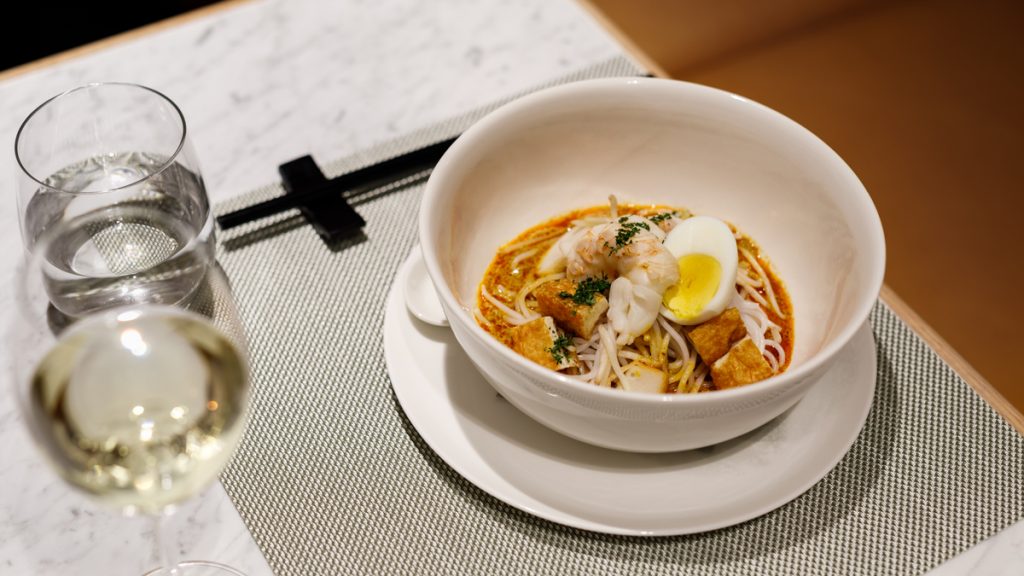 a bowl of soup with noodles and shrimp