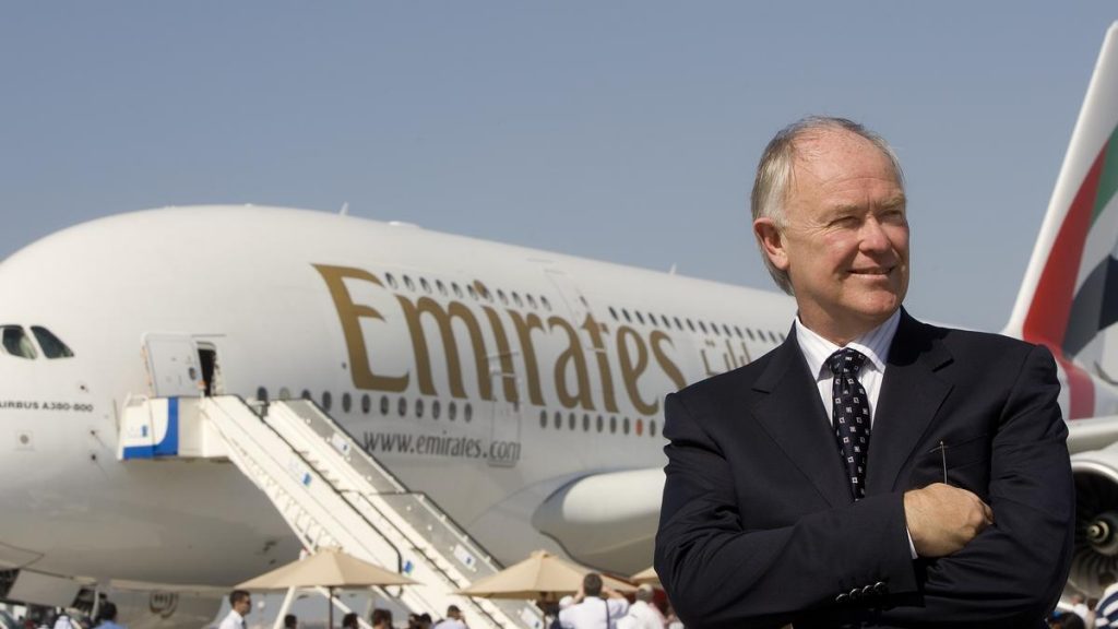 a man in a suit standing in front of an airplane
