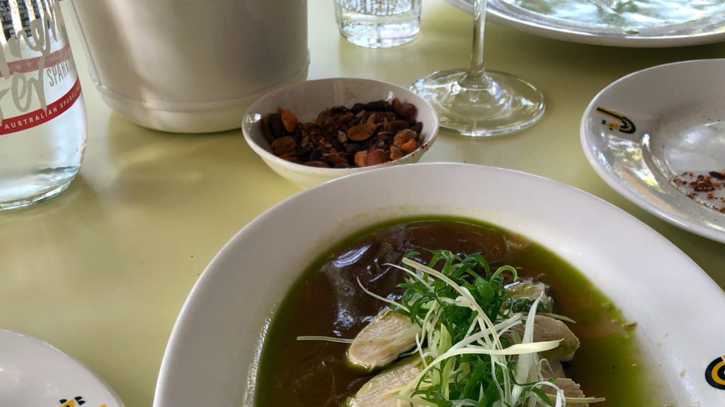 a bowl of soup with vegetables and herbs