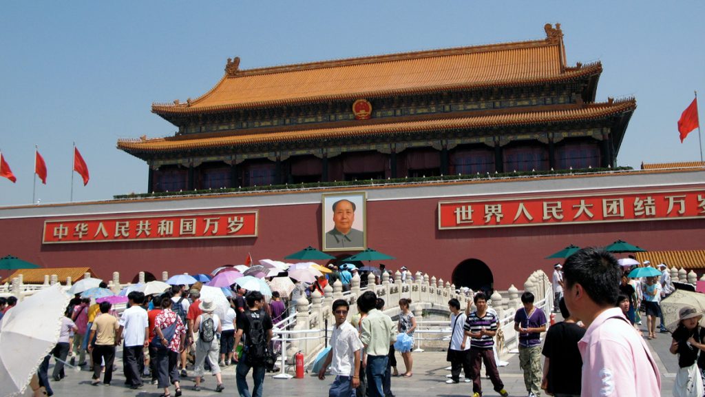 a group of people walking in front of Tiananmen Square