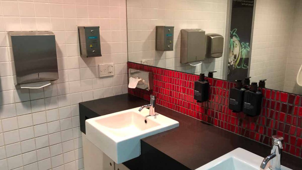 a bathroom with a sink and soap dispensers