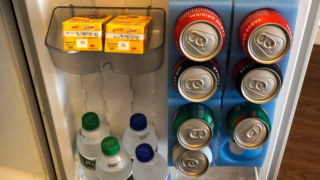 a group of cans and bottles in a fridge