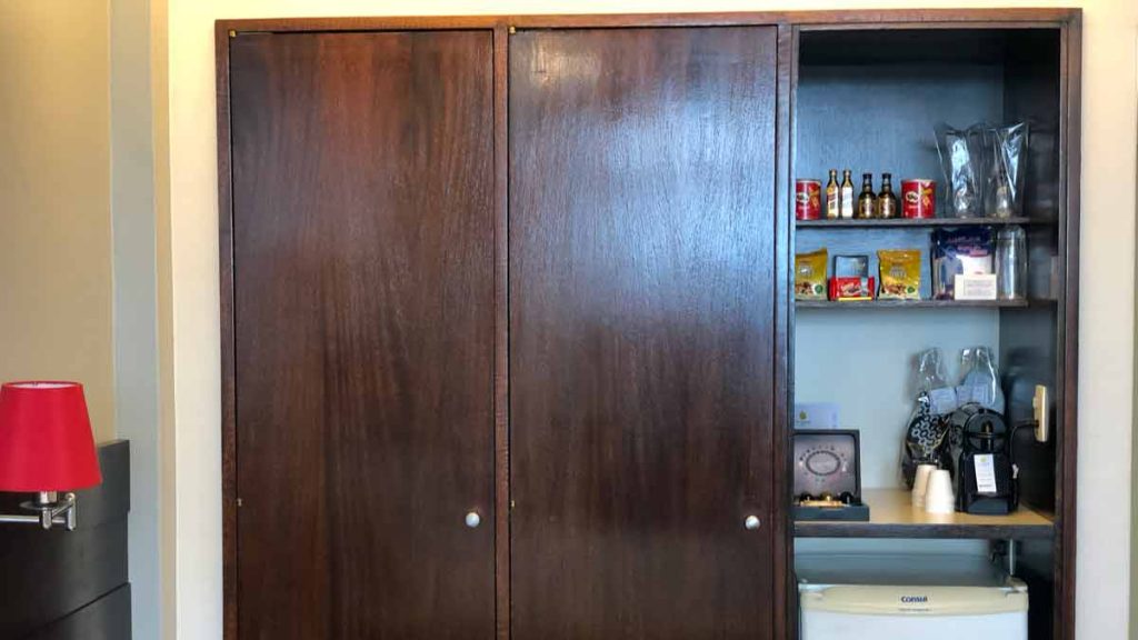 a cabinet with a shelf full of food and snacks