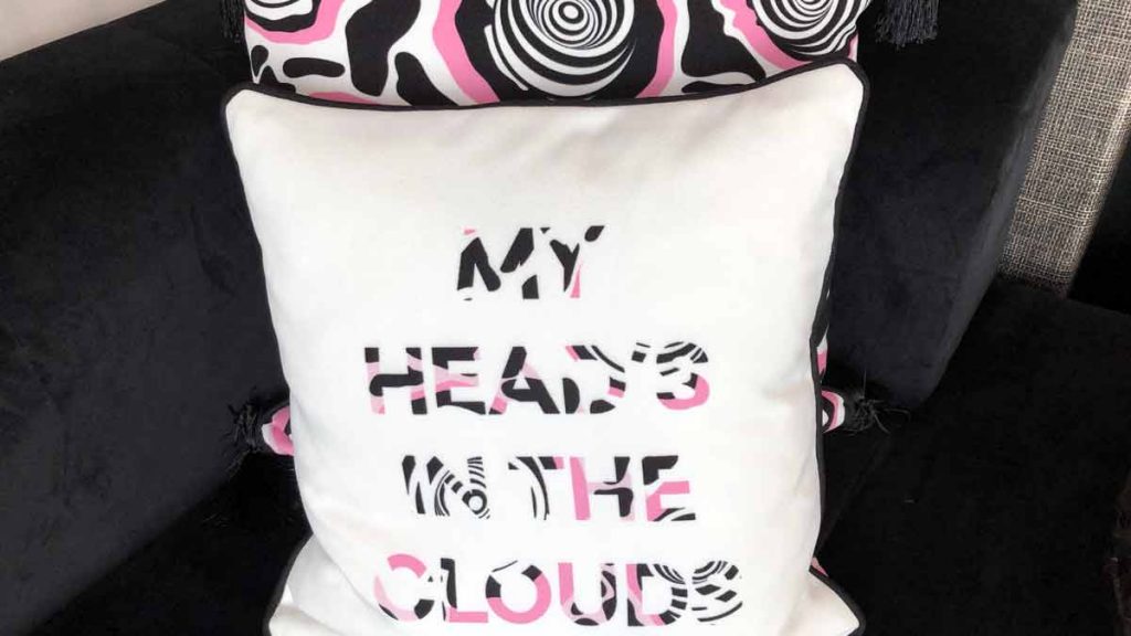 a white pillow with black and pink text