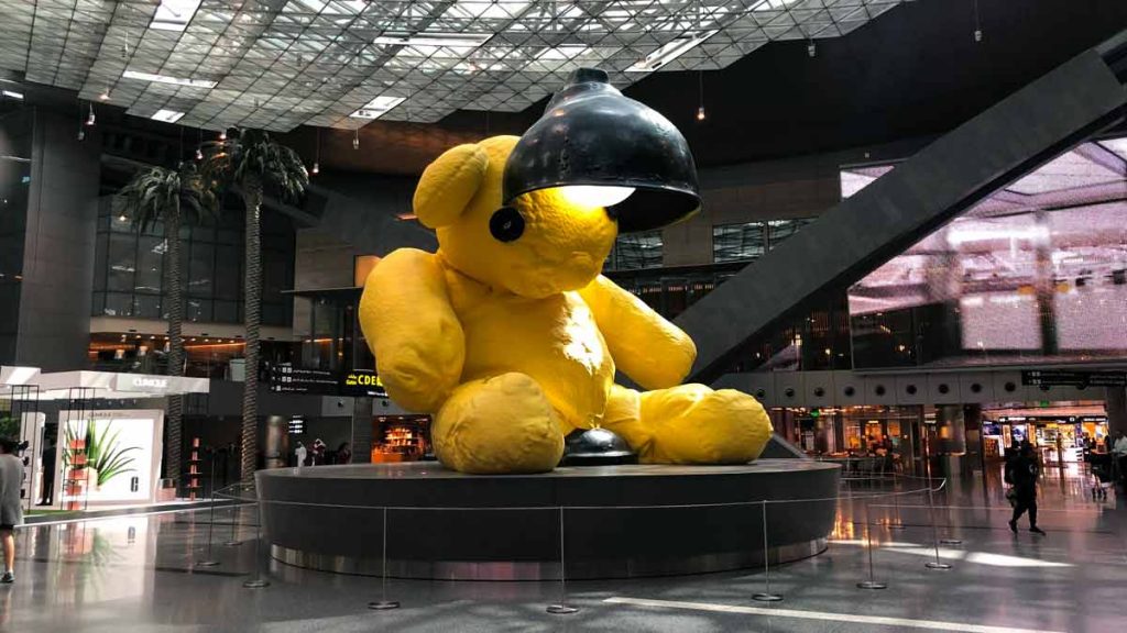 a large yellow teddy bear statue in a building