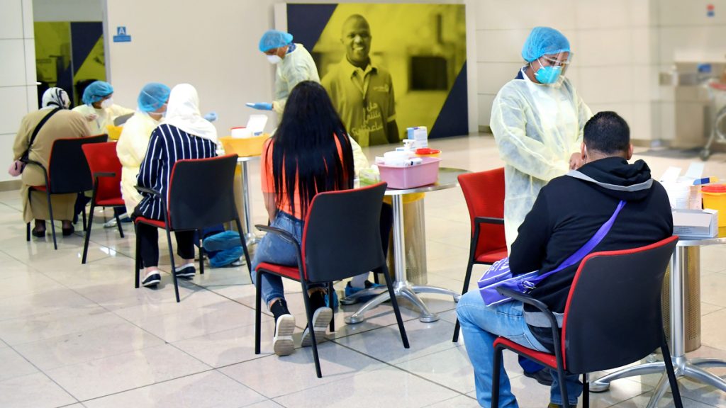 people in masks and masks sitting in chairs