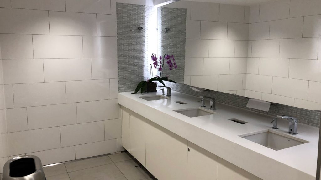 a bathroom with white counter tops and white tiles