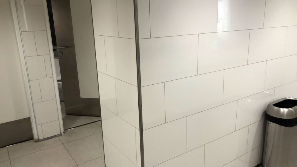 a white tile wall with a metal frame