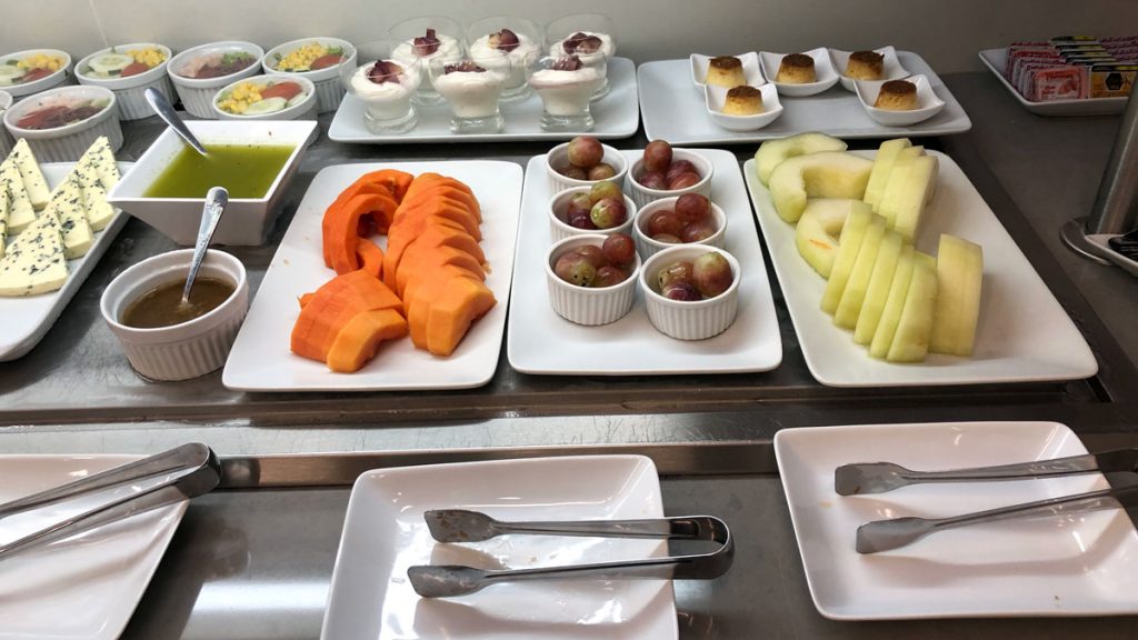 a table with plates of fruit and desserts