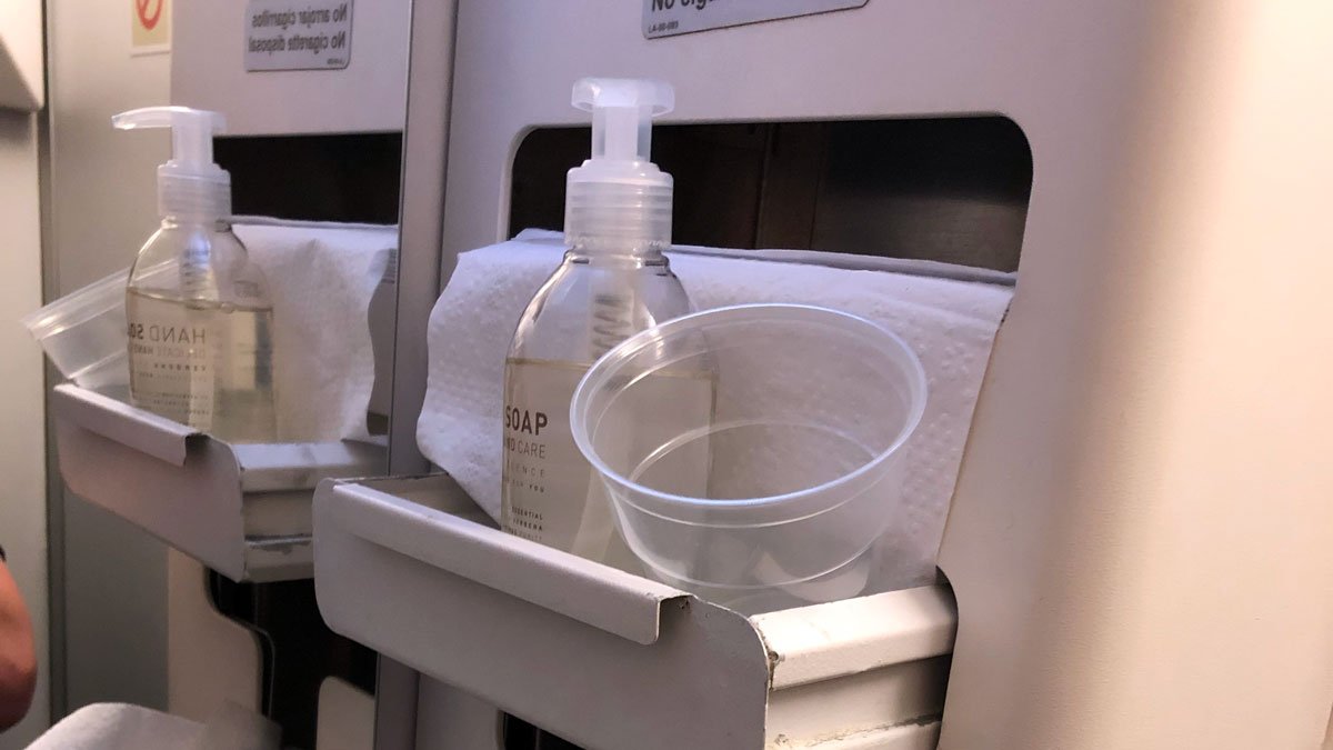 a soap bottle and a cup on a shelf