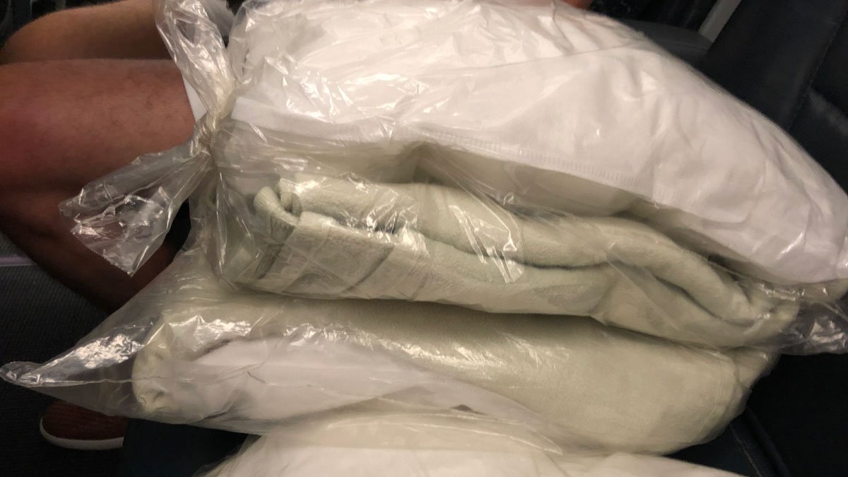 a stack of white blankets in plastic bags