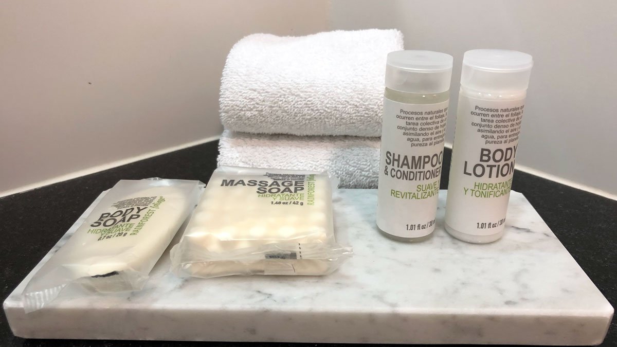 a group of toiletries and towels on a marble counter