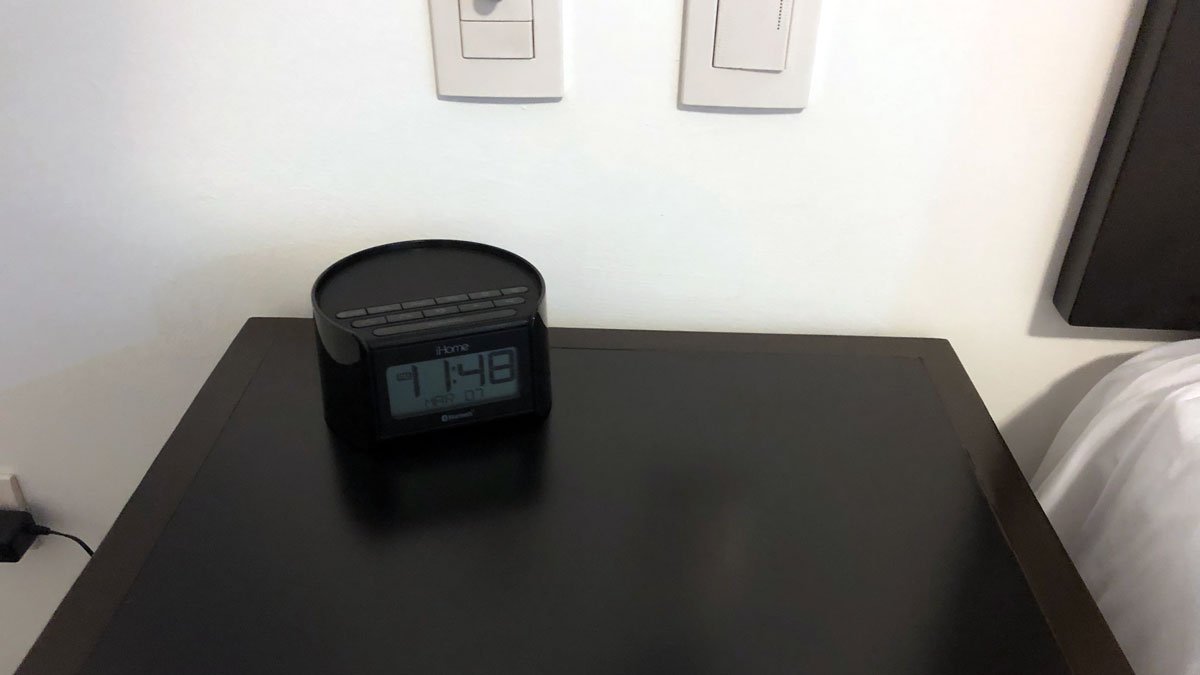a black alarm clock on a black surface